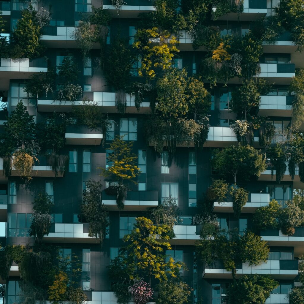 A vertical shot of a futuristic building with natural decorations on its facade